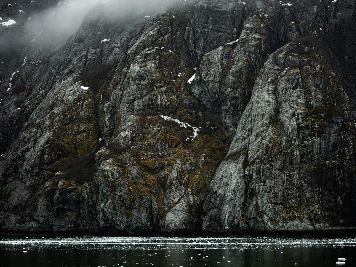 Misty sea cliff above the water